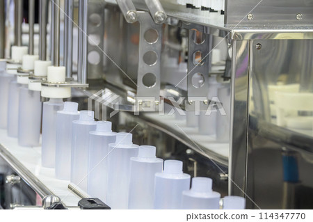 The  empty healthcare  bottles  on the conveyor belt for filling process. T 114347770