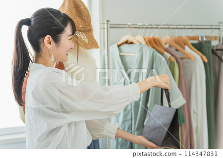 精選商店/服裝店微笑的女店員將紙袋遞給顧客 114347831