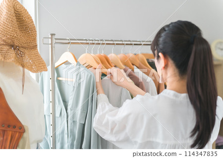 Smiling salesperson/employee/shop clerk Asian woman working in a shop/clothing store Smiling salesperson/employee/shop clerk Asian woman working in a shop/clothing store 114347835