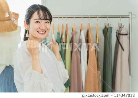 Smiling salesperson/employee/shop clerk Asian woman working in a shop/clothing store 114347838