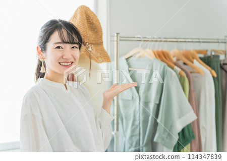 Smiling salesperson/employee/shop clerk Asian woman working in a shop/clothing store Smiling salesperson/employee/shop clerk Asian woman working in a shop/clothing store 114347839
