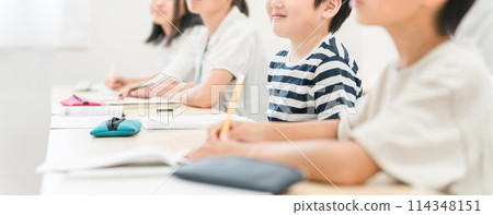 Elementary school boys and girls smiling while taking classes at a cram school or school 114348151