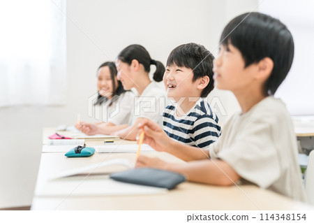 Elementary school boys and girls smiling while taking classes at a cram school or school 114348154