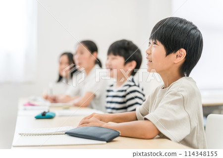 Elementary school boys and girls smiling while taking classes at a cram school or school 114348155