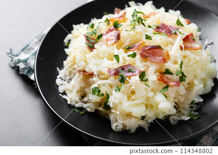 Slovak potato dumplings halusky with steamed sauerkraut and bacon on black background Slovak potato dumplings halusky with steamed sauerkraut and bacon on black background 114348802