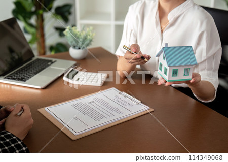 Real estate agent talking about the terms of the home purchase agreement and the customer to signing the documents to make the contract legally, Home sale and home insurance 114349068