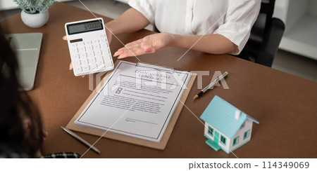 Real estate agent talking about the terms of the home purchase agreement and the customer to signing the documents to make the contract legally, Home sale and home insurance Real estate agent talking about the terms of the home purchase agreement and the customer to signing the documents to make the contract legally, Home sale and home insurance 114349069