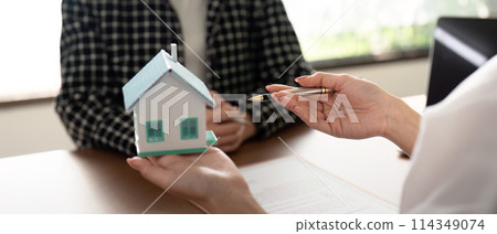 Real estate agent talking about the terms of the home purchase agreement and the customer to signing the documents to make the contract legally, Home sale and home insurance Real estate agent talking about the terms of the home purchase agreement and the customer to signing the documents to make the contract legally, Home sale and home insurance 114349074