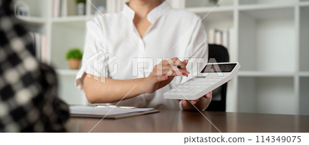 Real estate agent talking about the terms of the home purchase agreement and the customer to signing the documents to make the contract legally, Home sale and home insurance Real estate agent talking about the terms of the home purchase agreement and the customer to signing the documents to make the contract legally, Home sale and home insurance 114349075