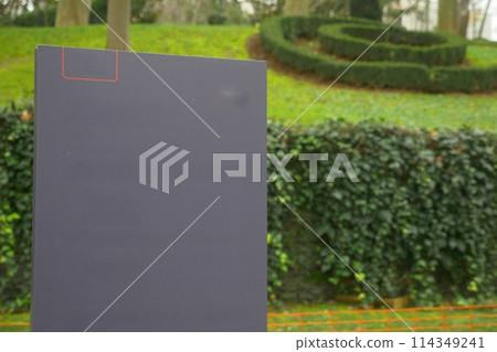 A black ciramic billboard stands in the park 114349241