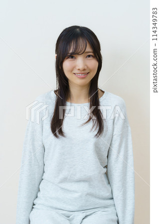 年輕女子坐在椅子上鍛鍊身體 年輕女子坐在椅子上鍛鍊身體 114349783