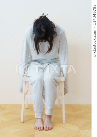 Young woman sitting on a chair and exercising 114349785