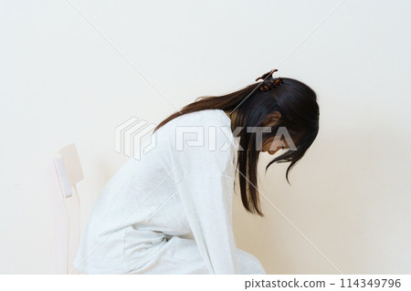 Young woman sitting on a chair and exercising 114349796