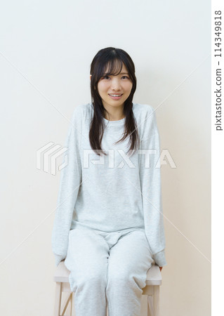 年輕女子坐在椅子上鍛鍊身體 年輕女子坐在椅子上鍛鍊身體 114349818
