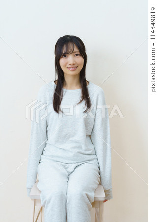 Young woman sitting on a chair and exercising 114349819