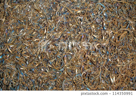 Close up shot of rusty curly dark metal shavings, ferrous metal scrap texture. Turning and miling industry theme or abstract steel scrap materials recycling industrial background. 114350991