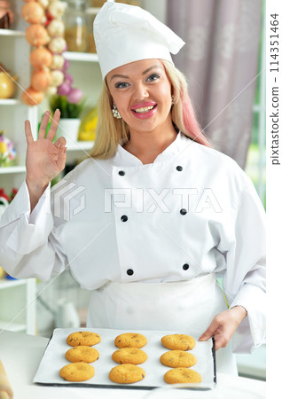 Beautiful young woman in chefs hat making dough 114351464