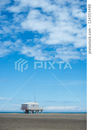 Gruissan - France - 27 April 2024 - view of wooden life guard station on the beach on beautiful cloudy sky background Gruissan - France - 27 April 2024 - view of wooden life guard station on the beach on beautiful cloudy sky background 114353499