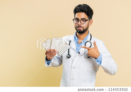 Indian doctor man show lot of tablet pills in blisters recommends drugs vitamin antibiotic treatment 114353502