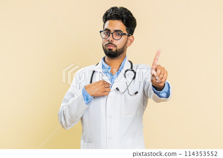 Confused upset Indian doctor man pointing fingers herself, rejection, refusal problem, stop sign Confused upset Indian doctor man pointing fingers herself, rejection, refusal problem, stop sign 114353552