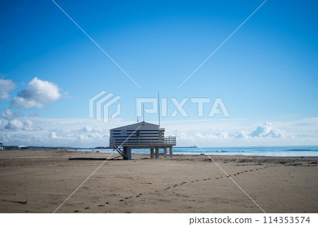 Gruissan - France - 27 April 2024 - view of wooden life guard station on the beach on beautiful cloudy sky background 114353574