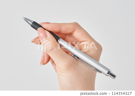 Woman's hand holding a black ballpoint pen and a white background 114354327