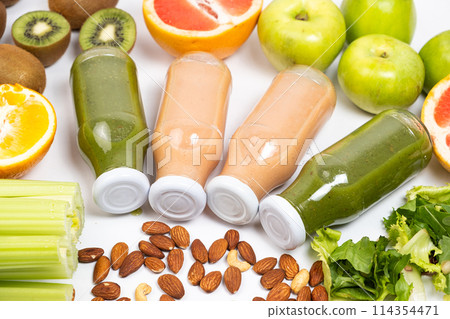 Different vegetable and fruit smoothies in glass bottles on white background 114354471