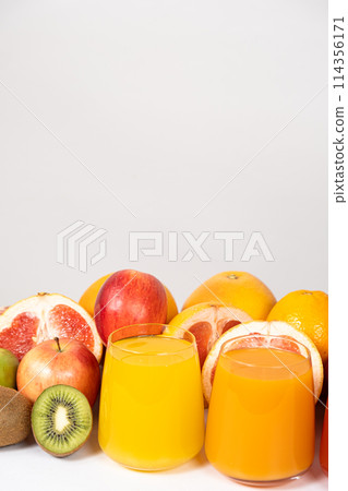 Orange and multifruit juices in glasses on white background with space for text Orange and multifruit juices in glasses on white background with space for text 114356171