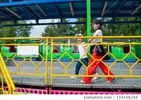 Kids having fun in ferris wheel with chains, carousel ski flyer in amusement park. Happy children, twins having fun outdoors on sunny day. High quality photo Kids having fun in ferris wheel with chains, carousel ski flyer in amusement park. Happy children, twins having fun outdoors on sunny day. High quality photo 114356284