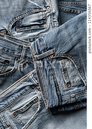 Group of aged blue denim jeans 114356867