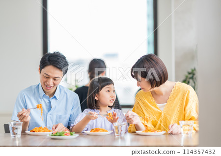 Parents and children eating at a restaurant. 114357432