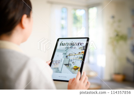 A woman who operates a tablet A woman who operates a tablet 114357856