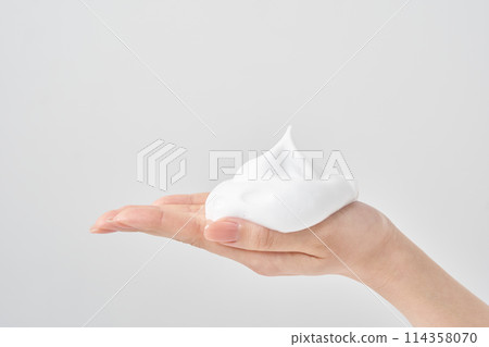 A woman's hand placing a small ball of foam on her palm 114358070