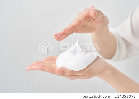 一個女人的手將一團細泡沫放在她的手掌上 114358072