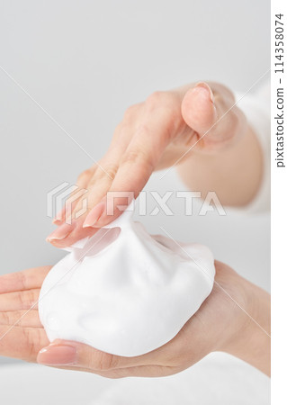 A woman's hand placing a small ball of foam on her palm 114358074