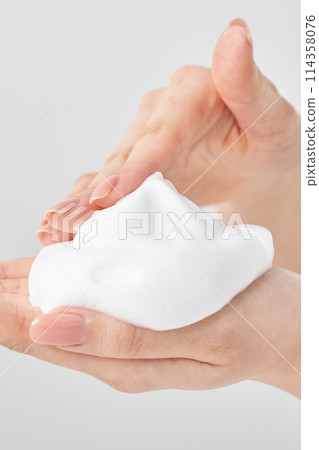 A woman's hand placing a small ball of foam on her palm 114358076