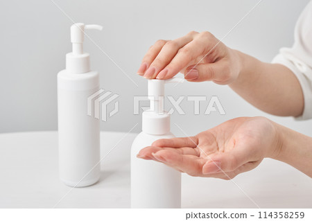 White bottle and female hand White bottle and female hand 114358259