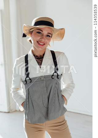 Portrait of a beautiful fashionable young woman in summer suit and hat 114358539