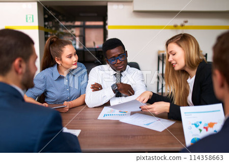 Diverse corporate team in office engage in analytics. Global staff review charts, discuss strategy. Pro group works on project, brainstorm ideas. Multiethnic teamwork, planning in meeting room. Diverse corporate team in office engage in analytics. Global staff review charts, discuss strategy. Pro group works on project, brainstorm ideas. Multiethnic teamwork, planning in meeting room. 114358663