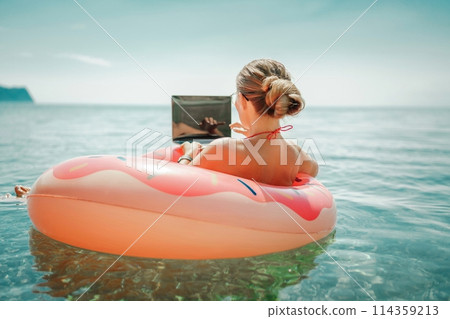 Woman laptop sea. Freelancer woman in sunglases floating on an inflatable big pink donut with a laptop in the sea. People summer vacation rest lifestyle concept Woman laptop sea. Freelancer woman in sunglases floating on an inflatable big pink donut with a laptop in the sea. People summer vacation rest lifestyle concept 114359213