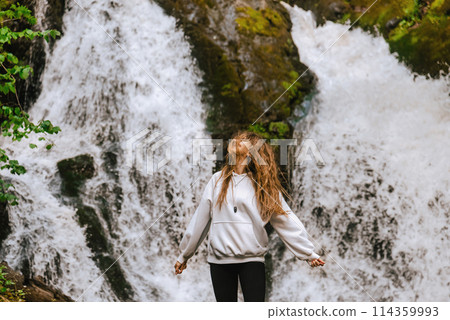 Woman Traveler Enjoying Mountain Waterfall Landscape Woman Traveler Enjoying Mountain Waterfall Landscape 114359993