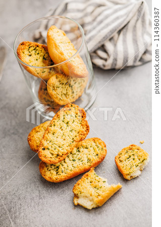 Garlic crisp bread Slices Topped With Herbs on kitchen table. 114360387