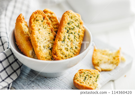 Garlic crisp bread Slices Topped With Herbs in bowl. Garlic crisp bread Slices Topped With Herbs in bowl. 114360420