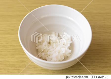 A little bit of rice in a bowl. An image of poverty. 114360428