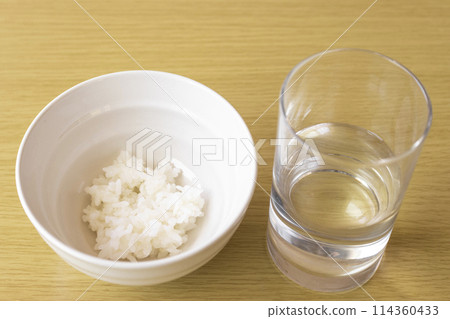 A bowl of rice and tap water. An image of poverty. A bowl of rice and tap water. An image of poverty. 114360433