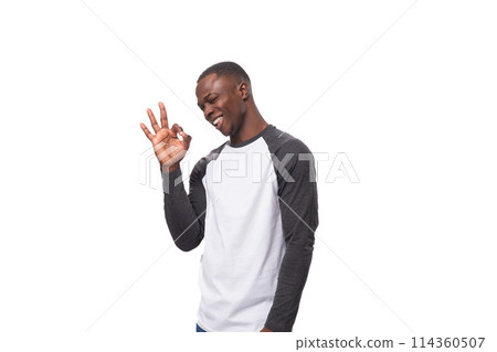 young charismatic african man dressed casual smiling on white background with copy space 114360507