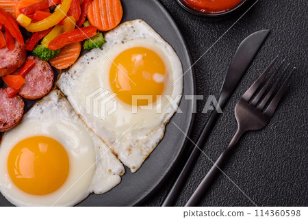 Delicious nutritious breakfast with fried eggs, sausage, steamed vegetables 114360598