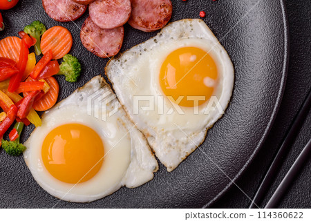 Delicious nutritious breakfast with fried eggs, sausage, steamed vegetables Delicious nutritious breakfast with fried eggs, sausage, steamed vegetables 114360622
