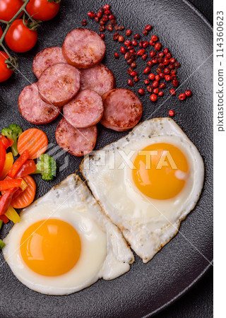 Delicious nutritious breakfast with fried eggs, sausage, steamed vegetables Delicious nutritious breakfast with fried eggs, sausage, steamed vegetables 114360623