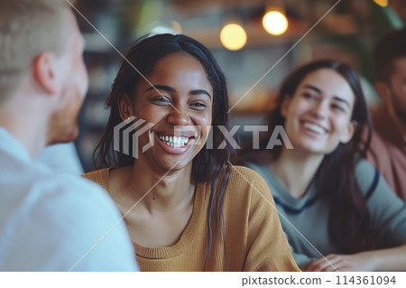 a cheerful group of friends sitting at a table talking in a cafe a cheerful group of friends sitting at a table talking in a cafe 114361094